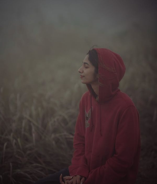 Woman in a calm breathing pose with a serene azure mist effect around her.
